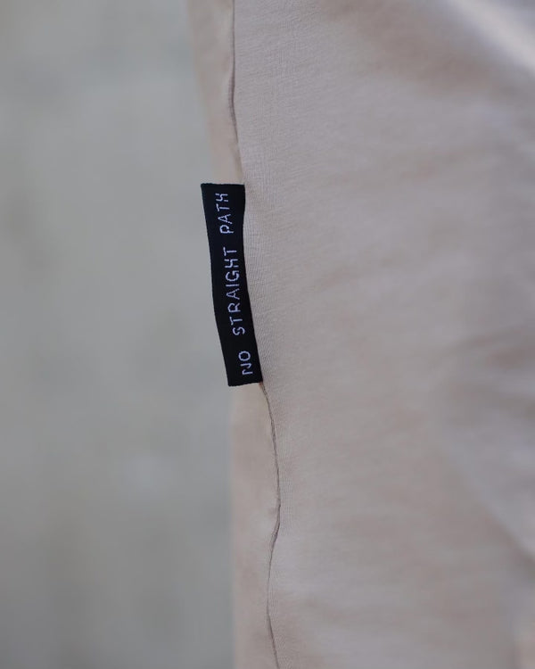 Label on a beige fabric with 'No Straight Path' text.