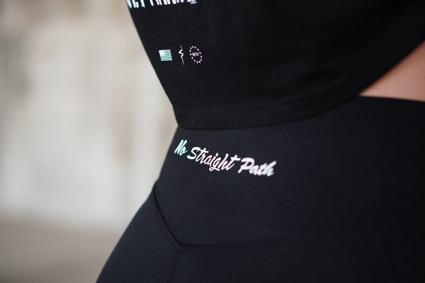 Black outfit with No Straight Path® text and logos on a blurred background