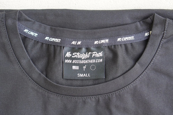Close-up of a black t-shirt with a label on the collar displaying 'No Straight Path' branding.