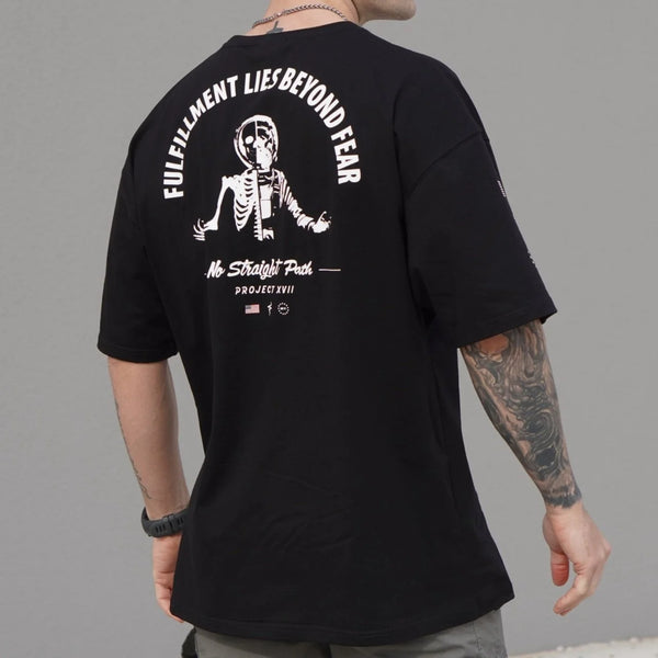 Person wearing a black t-shirt with a white graphic and text on the back, against a gray background.