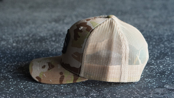 Camouflage baseball cap on a textured dark surface