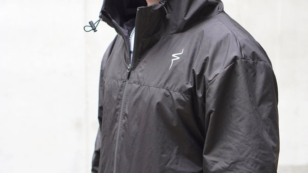 Black jacket with a No Straight Path® logo on a light gray background