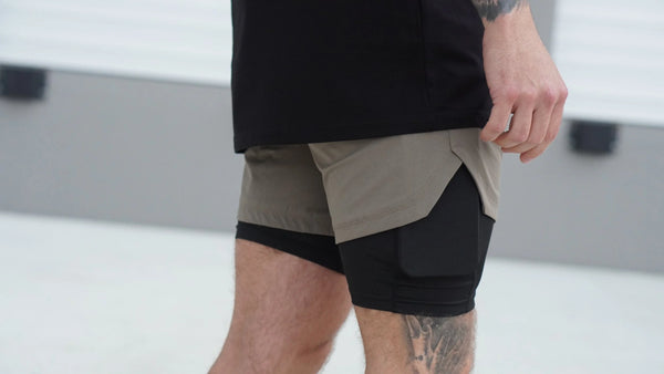 Person wearing a black and beige athletic outfit with shorts on a blurred background