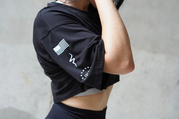 Person wearing a black athletic outfit with white graphics on a neutral background