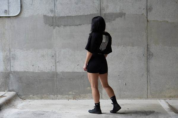 Person wearing a black No Straight Path® outfit against a concrete wall.