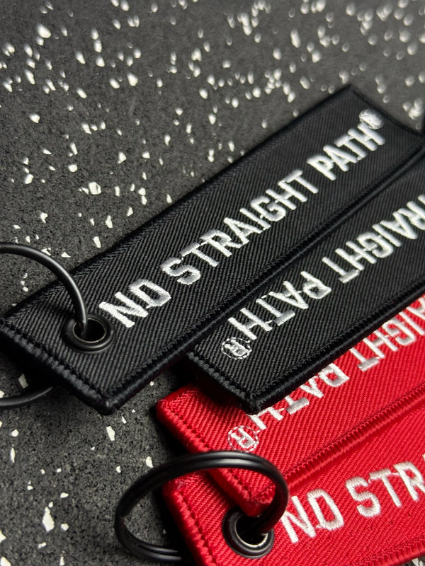 Black and red strap with No Straight Path® text on a textured surface