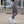 Person wearing gray leggings and white sneakers on a rooftop with cityscape background