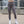 Female wearing gray leggings and white sneakers on a rooftop with cityscape background