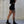 Girl wearing black shorts and shoes with a concrete wall background