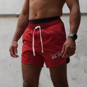 Person wearing red shorts with 'ALL IN.' text on a light background