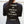 Person wearing a black shirt with motivational text reading 'Conquer all obstacles. Pursue fulfillment.' against a plain background