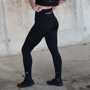 Female wearing black leggings with No Straight Path® text on a concrete floor and wall background