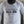 White long-sleeve shirt with motivational text 'No Limits. No Excuses. ALL IN.' on a blurred background