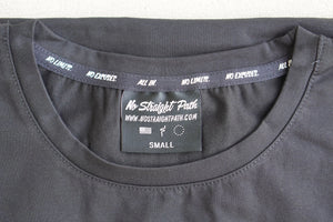 Close-up of a black t-shirt with a label on the collar displaying 'No Straight Path' branding.