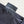 Black shirt with a tag that reads 'Fulfillment Lies Beyond Fear' on a neutral background