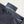 Black shirt with a tag that reads 'Fulfillment Lies Beyond Fear' on a neutral background