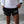 Person wearing black shorts with 'ALL IN.' text and a white shirt, standing against a neutral background.