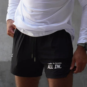 Person wearing black shorts with 'ALL IN.' text, white long-sleeve shirt, and gray background