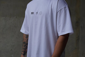 White t-shirt with No Straight Path® logos on the front, worn by a person with tattoos, against a neutral background.