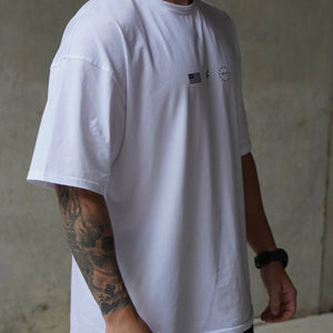 Person wearing a white t-shirt with small No Straight Path® logos against a plain background