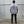 Person wearing a white t-shirt with motivational text reading 'Conquer all obstacles. Pursue Fulfillment.' on the back, standing against a concrete wall.