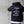 Person wearing a black hoodie with motivational text on the back against a concrete wall.