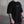 Person wearing a black t-shirt with a small No Straight Path® logo in a concrete setting