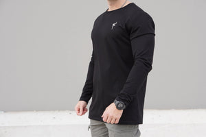 Person wearing a black long-sleeve shirt with a No Straight Path® logo on a gray background
