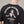 Person wearing a black t-shirt with a skeleton design and text on the back, against a neutral background.