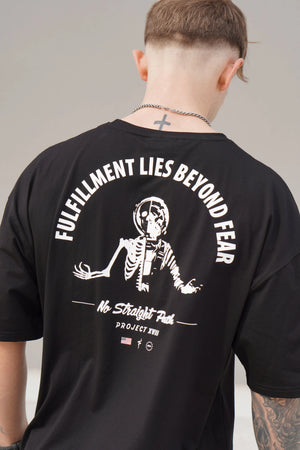 Person wearing a black t-shirt with a skeleton design and text on the back, against a neutral background.