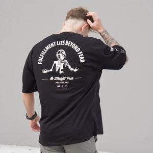 Person wearing a black t-shirt with white graphic design on the back, standing against a plain background.