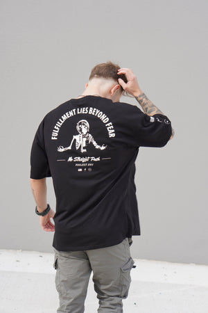 Person wearing a black t-shirt with white graphic design on the back, standing against a plain background.