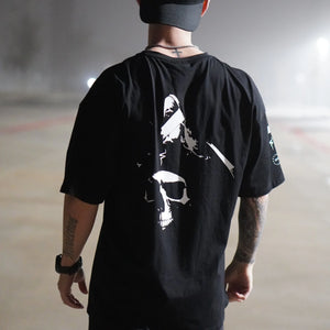 Person wearing a black t-shirt with a white  No Straight Path® skull graphic design, standing on a foggy road.