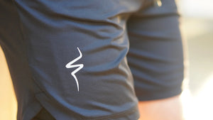 Close-up of black shorts with a white No Straight Path® logo on a blurred background