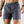 Person wearing gray-blue athletic shorts on a plain background