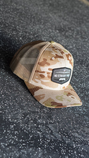 Camouflage baseball cap with a brand logo on a textured surface