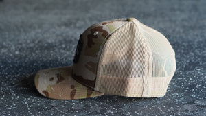 Camouflage baseball cap on a textured dark surface