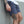 Person wearing gray-blue shorts with visible tattoos on a plain background