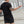 Man in black t-shirt and shorts standing outdoors with arms outstretched