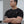 Man wearing a black t-shirt with a white No Straight Path® logo, standing against a neutral background
