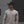 Man wearing a beige long-sleeve shirt with a No Straight Path® logo on a blurred background.