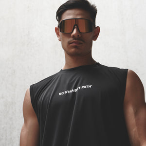 Man wearing a black sleeveless shirt with text and reflective sunglasses against a light background