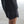 Person wearing black shorts with white No Straight Path® logo on a light gray pavement.