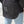 Person wearing a black jacket with white reflective stripes on a neutral background
