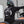 Person wearing a black tee with a white graphic on a Harley motorcycle.