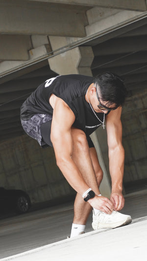 Person tying shoelaces in an urban setting