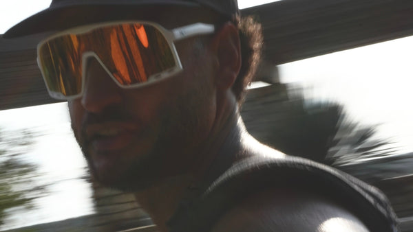 Person wearing a black cap and reflective sunglasses with a blurred background