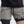 Person wearing gray shorts with a black waistband and 'All In' text on a light background