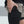 Person wearing black shorts with a phone pocket, standing on a light background