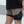 Person wearing a black and beige athletic outfit with shorts on a blurred background